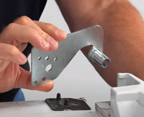 close up of hands replaceing the upper door hinge on a refrigerator