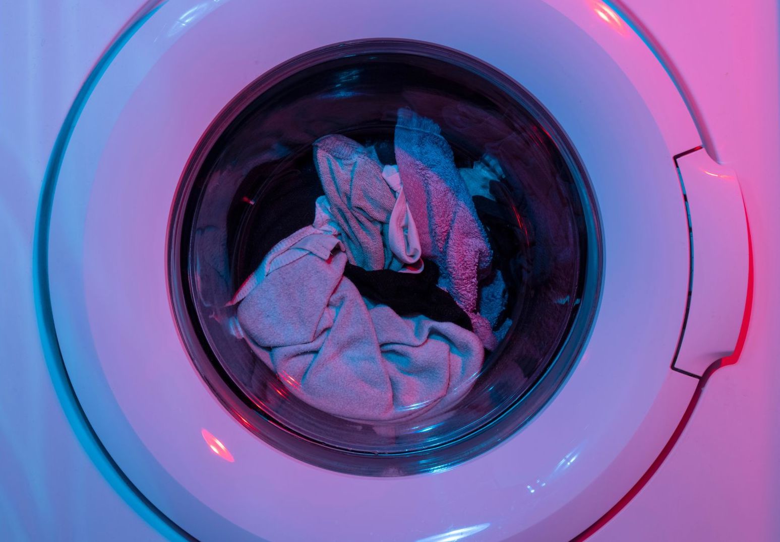 garments spinning around in washing machine getting cleaned during cycle using the correct water temperature