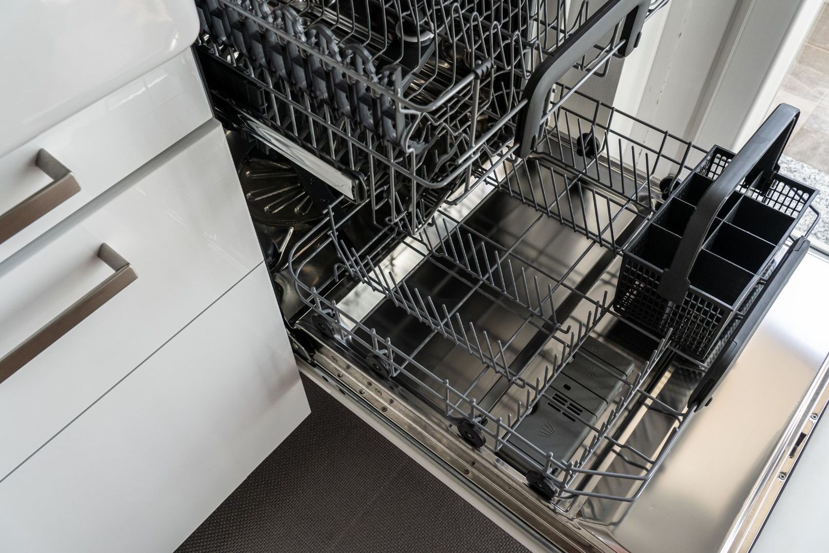 Dishwasher pulled out to inspect dishwasher insulation