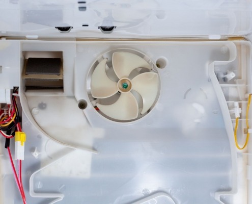 interior of refrigerator with fan and wiring